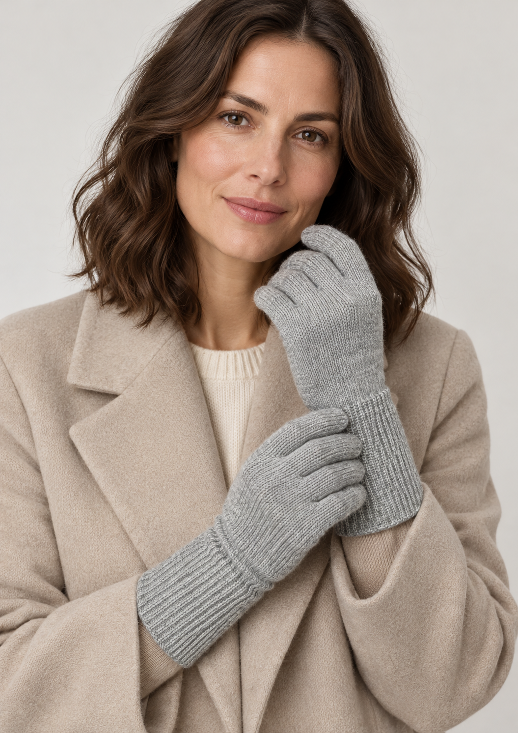 Model wearing light grey s.Oliver knitted gloves with a beige coat against a neutral studio background